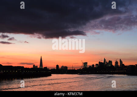London, Großbritannien. 30.. Oktober 2017. Der atemberaubende Sonnenuntergang über der City of London erleuchtet die ikonischen Gebäude, die kürzlich in London entstanden sind, und die riesige Anzahl von Turmdrehkräne, die noch mehr Wolkenkratzer erschaffen. Das Foto wurde vom Flussufer an der Canary Wharf aufgenommen. Kredit: Nigel Bowles/Alamy Live Nachrichten Stockfoto