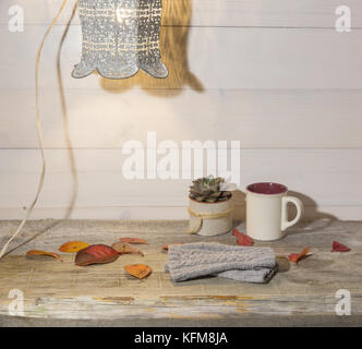 Herbst Hintergrund, wollene Handschuhe, bunte Blätter, saftig, Tasse Kaffee auf einen alten Holztisch und retro Lampe Stockfoto