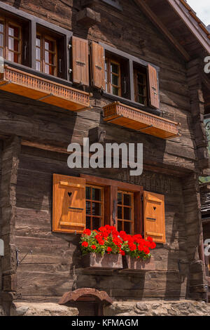 Zinal, Schweiz - traditionelles Haus im Dorf mit Blume, Walliser Alpen Berge, Kanton Wallis. Stockfoto