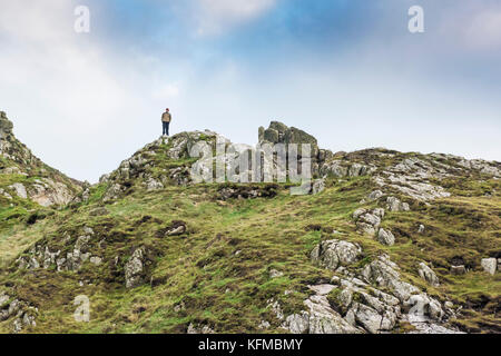 Cot Valley Cornwall - ein einsamer Mann, der auf einem Felsvorsprung mit Blick auf Cot Valley in Cornwall steht. Stockfoto