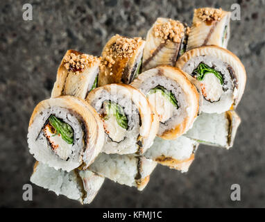 Rolle mit geräuchertem Aal, Salat und Frischkäse über konkreten Hintergrund Stockfoto