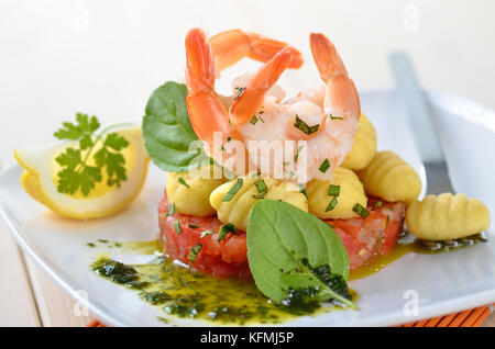 Italienische gnocci und Tiger Garnelen auf ragout Tomaten mit Basilikum und Olivenöl Stockfoto