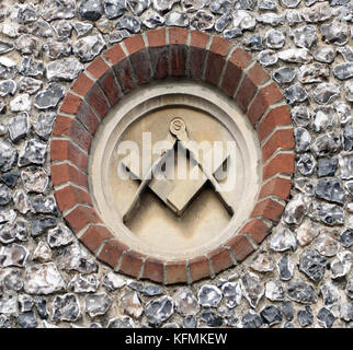 Zirkel und Square, freimaurersymbole auf Stein Plagen in einem feuerstein Wand geschnitzt auf einem alten Masonic Hall. Winchester, Hampshire, UK Stockfoto