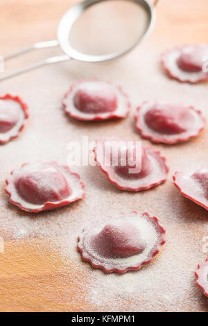 Lecker Rote-bete-Ravioli mit Mehl. Stockfoto