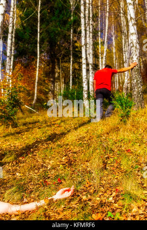 Arm auf dem Boden mit Mann Abbildung gegen einen Baum im Hintergrund - Tatort enactment Stockfoto