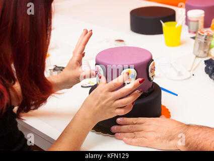 Gebäck Lektion, die auf Zahlen von Halloween mit Fondant einfügen oder Zuckerpaste. Stockfoto