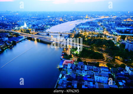 Bangkok und den Fluss Chao Phraya Skyline der Stadt, in der Nähe von Phra phuttha yodfa Brücke unter Purple Dämmerung Abendhimmel. Thailand Kapital von Unternehmen. Stockfoto