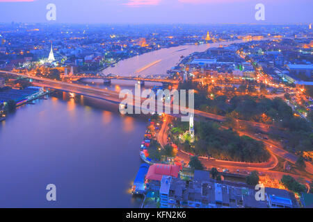 Bangkok und den Fluss Chao Phraya Skyline der Stadt, in der Nähe von Phra phuttha yodfa Brücke unter Purple Dämmerung Abendhimmel. Thailand Kapital von Unternehmen. Stockfoto