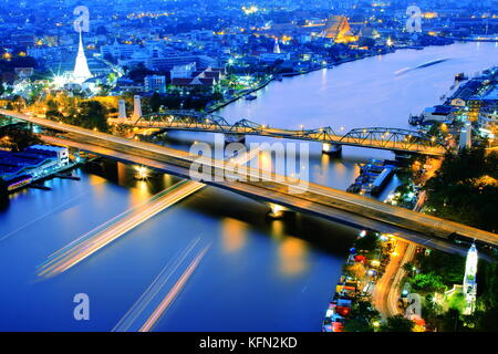 Bangkok und den Fluss Chao Phraya Skyline der Stadt, in der Nähe von Phra phuttha yodfa Brücke unter Purple Dämmerung Abendhimmel. Thailand Kapital von Unternehmen. Stockfoto