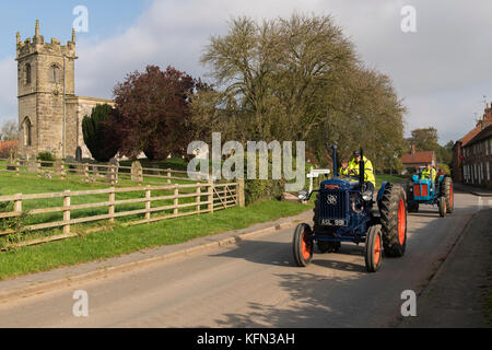 Mann, der alten blauen Oldtimer Traktor durch Dorf Bugthorpe auf Wolds Vintage Gruppe Straße laufen, eine jährliche Charity Event - Yorkshire, England, UK. Stockfoto