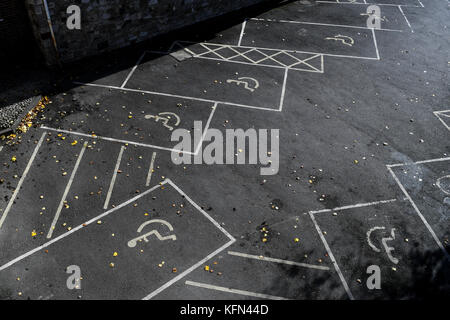 Leere Behindertenparkplätze mit Rollstuhl Markierungen auf von oben fotografiert. Stockfoto