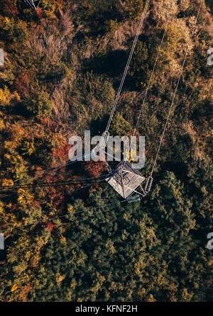 Luftaufnahme von Strom Pylon im Feld, Blick von oben auf die industrielle Infrastruktur von Drone pov. Stockfoto