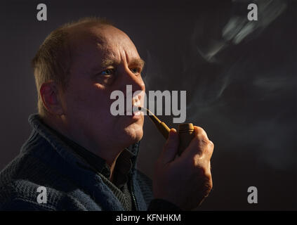 Schönes Portrait von einem kaukasischen Mann mit tabakpfeife (Low Key) Stockfoto