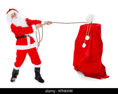 Santa ziehen Geschenke sack auf weißem Hintergrund Stockfoto