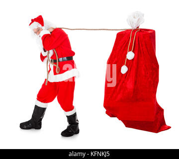 Santa ziehen Geschenke sack auf weißem Hintergrund Stockfoto