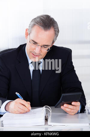 Gerne reife Geschäftsmanns, der auf dem Computer im Büro Stockfoto