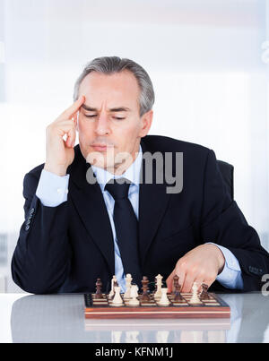 Porträt eines reifen Geschäftsmann Schach spielen Stockfoto