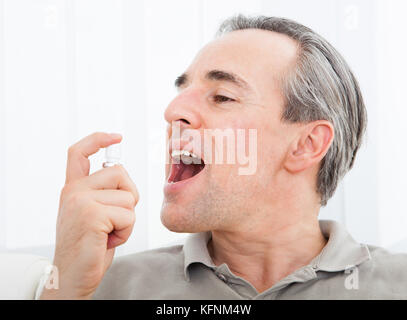 Nahaufnahme eines Mannes frischen Atem Spray anwenden Stockfoto