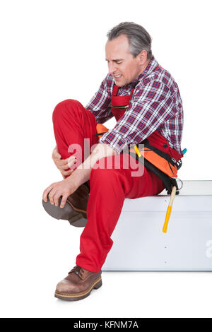 Männliche Techniker Knie Schmerzen leiden isoliert auf weißem Hintergrund Stockfoto