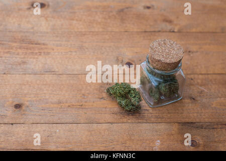 Ein Glas mit medizinischen Marihuana auf einem Holztisch. Stockfoto