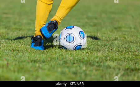Nahaufnahme der Füße eines Fußballspielers Dribbling. Stockfoto