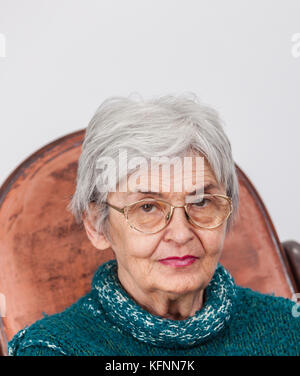 Portrait auf eine zerknitterte alte Frau mit Brille in die Kamera schaut. Stockfoto