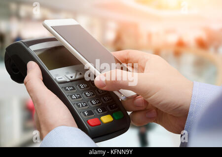 Mann mit Kreditkartenzahlung Maschine. Mobile Payment mit kontaktlosen Smart Phone Application Stockfoto