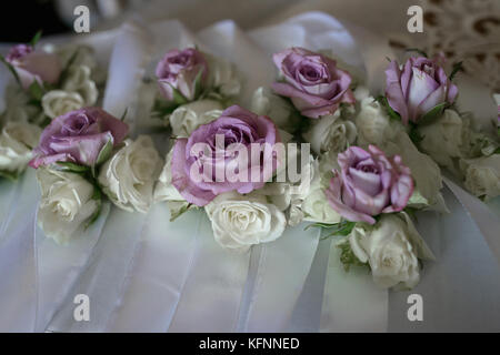 Blumenschmuck mit dünnen Papier lila Rosen, Zubehör für Hochzeiten, Detail, auf einem weißen Tuch positioniert Stockfoto