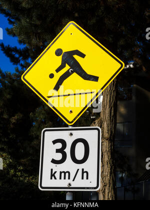 Warnschilder, die vor spielenden Kindern warnen, und Geschwindigkeitsbegrenzung von 30 km/h Stockfoto