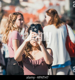 Prag, Tschechische Republik, 30. September 2017: Junge Frau nimmt Fotos mit ihr auf der Karlsbrücke Smartphone während schönen Herbsttag, Prag, CZ Stockfoto