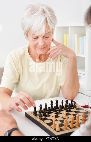 Ältere Frau schach spielen mit ihrem Ehemann Stockfoto