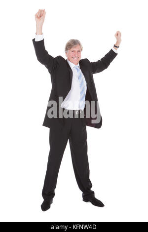 Porträt von glücklich reifer Geschäftsmann Erhöhung Arm Over White Background Stockfoto