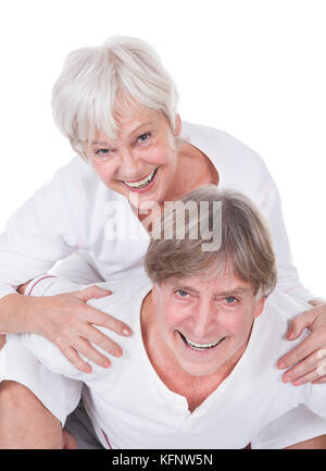 Glücklich Senior Mann unter einem Piggyback Frau Over White Background Stockfoto