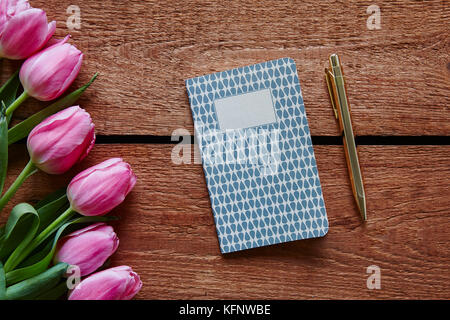 Stift und Tagebuch bereit Frühling Atmosphäre mit rosa Tulpen zu schreiben Stockfoto
