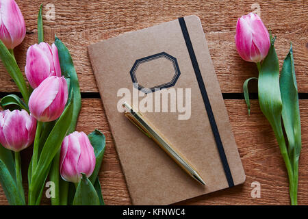 Retro Notebook mit rosa Tulpen im Frühjahr Atmosphäre umgeben Stockfoto