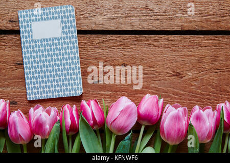 Schreiben Tagebuch im spriing rosa Tulpen und Holz Stockfoto