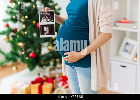 Schwangere Frau mit Ultraschall Bilder zu Weihnachten Stockfoto