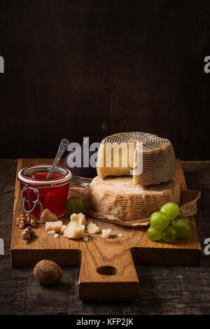 Dunkle Stillleben mit Käse, Früchte und Wein Stockfoto