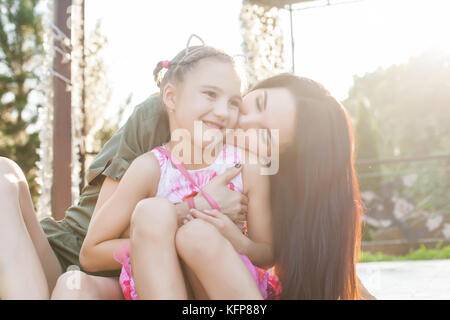 Mutter und Tochter küssen und umarmen in der Natur Stockfoto