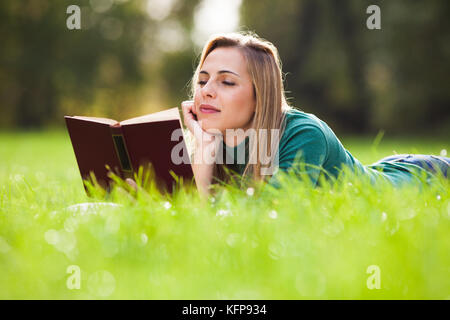 Junge Frau mit einem Buch in den Park Stockfoto