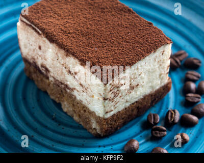 Schicht von tiramisu auf blauen Platte auf grauem Hintergrund Stockfoto