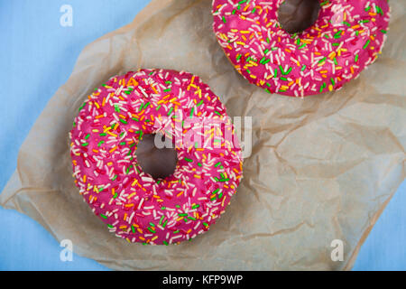 Rosa donuts Close-up auf einem hölzernen Hintergrund. leckeres Dessert. Stockfoto