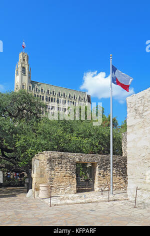 Eingang zum Alamo mission Gründen mit dem Staat Flagge und der historischen Emily Morgan Hotel im Hintergrund in der Innenstadt von San Antonio, Texas Stockfoto