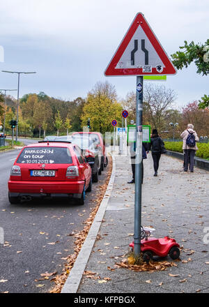 Rote Spielzeugauto angekettet an Verkehrszeichen in Wannsee Straße Stockfoto