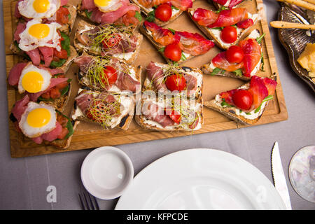 Auswahl an leckeren Bruschetta oder Häppchen auf taosted Baguette und Quark Käse garniert mit geräuchertem Lachs, Fleisch, Tomate und Chorizo Wurst, Thunfisch, salmo Stockfoto