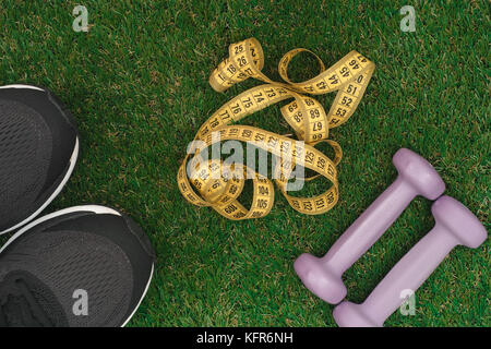 Im freien Fitness. sport Schuhe mit Maßband auf grünem Gras. Bis zu schließen. Stockfoto