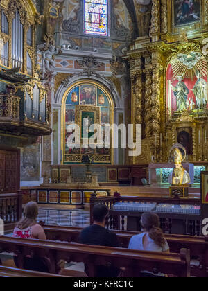 Besucher sitzen auf Bänken Hören von Audio Guides in der Kirche von San Nicolas (Parroquia de san nicolas), Ciutat Vella, Valencia, Spanien. Stockfoto