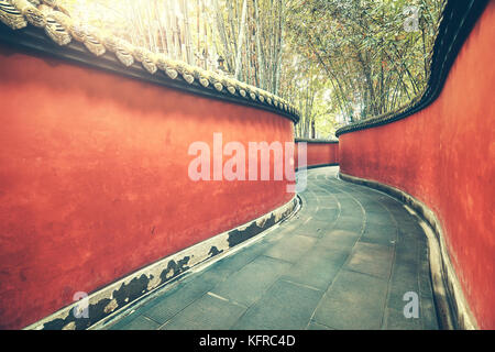Curvy rote Wand Passage von Bambus Wald umgeben, Farbe Tonen angewendet, Wuhou Tempel, Chengdu, China. Stockfoto