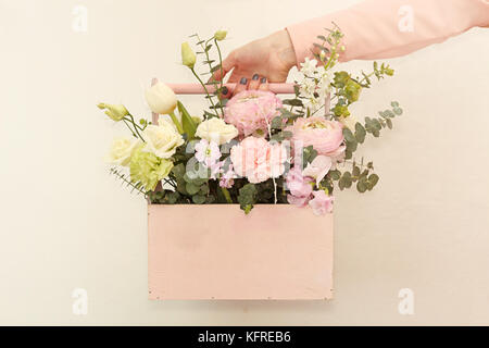 Rosa Holzbox mit Blumen Rosen und Nelken auf weißem Hintergrund Stockfoto