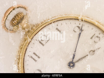 Eine Makroaufnahme einer alten Taschenuhr mit Eis bedeckt. Stockfoto